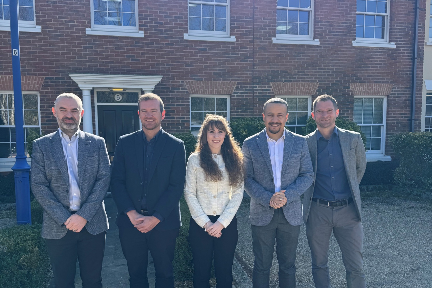 The Caliber Financial Management team standing outside the new office space in Ampthill