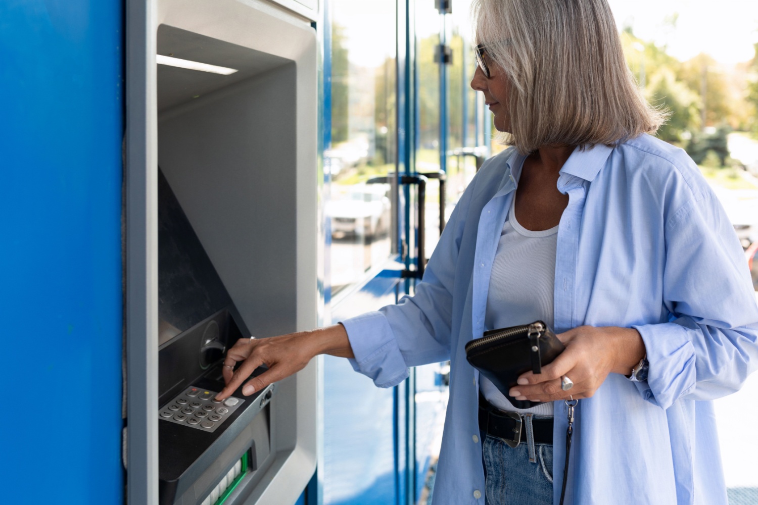 An older woman using a cash machine