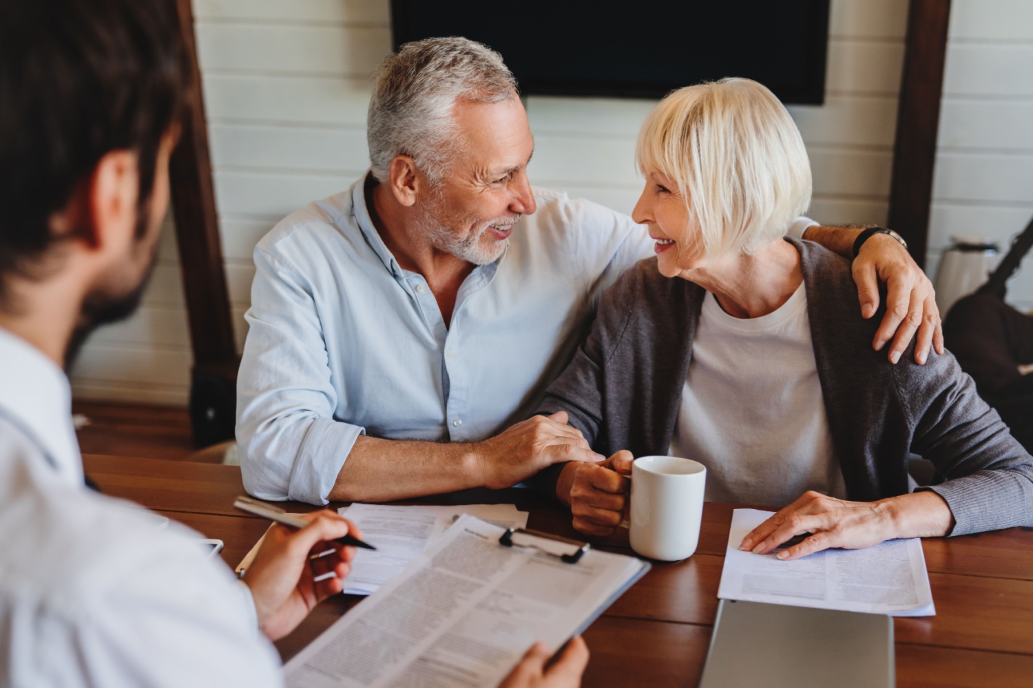 senior couple smiling as they speak with an adviser