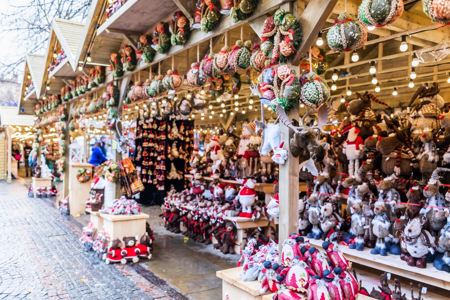 Christmas market stalls in traditional wooden booths selling festive goods.