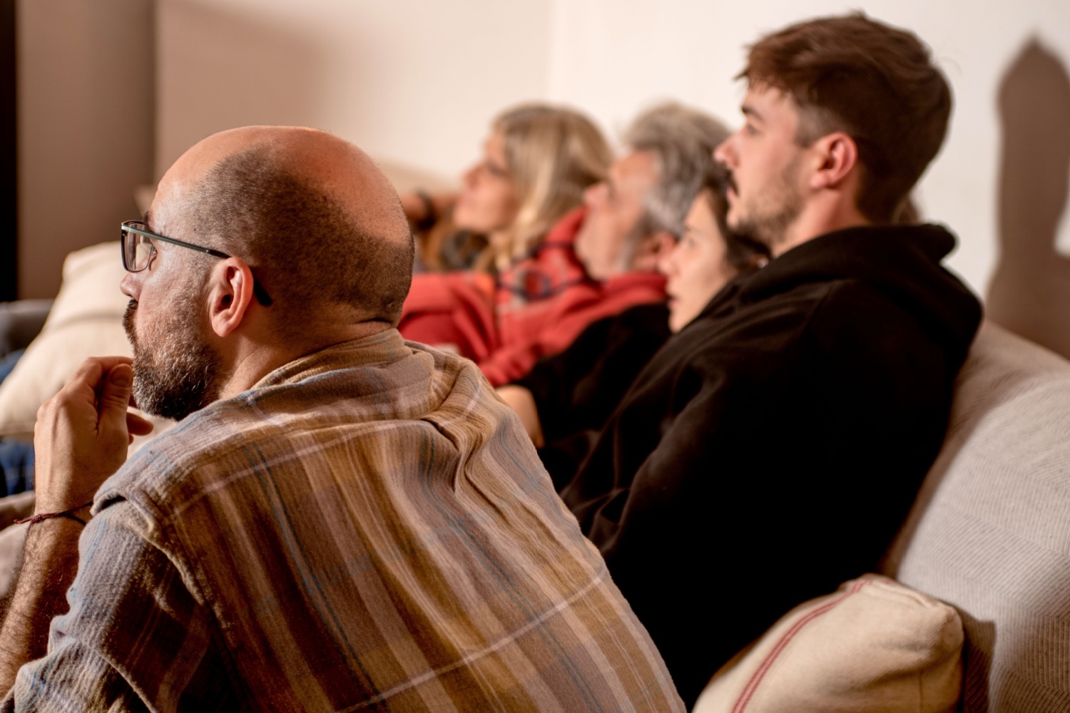 A family nervously watching the TV.